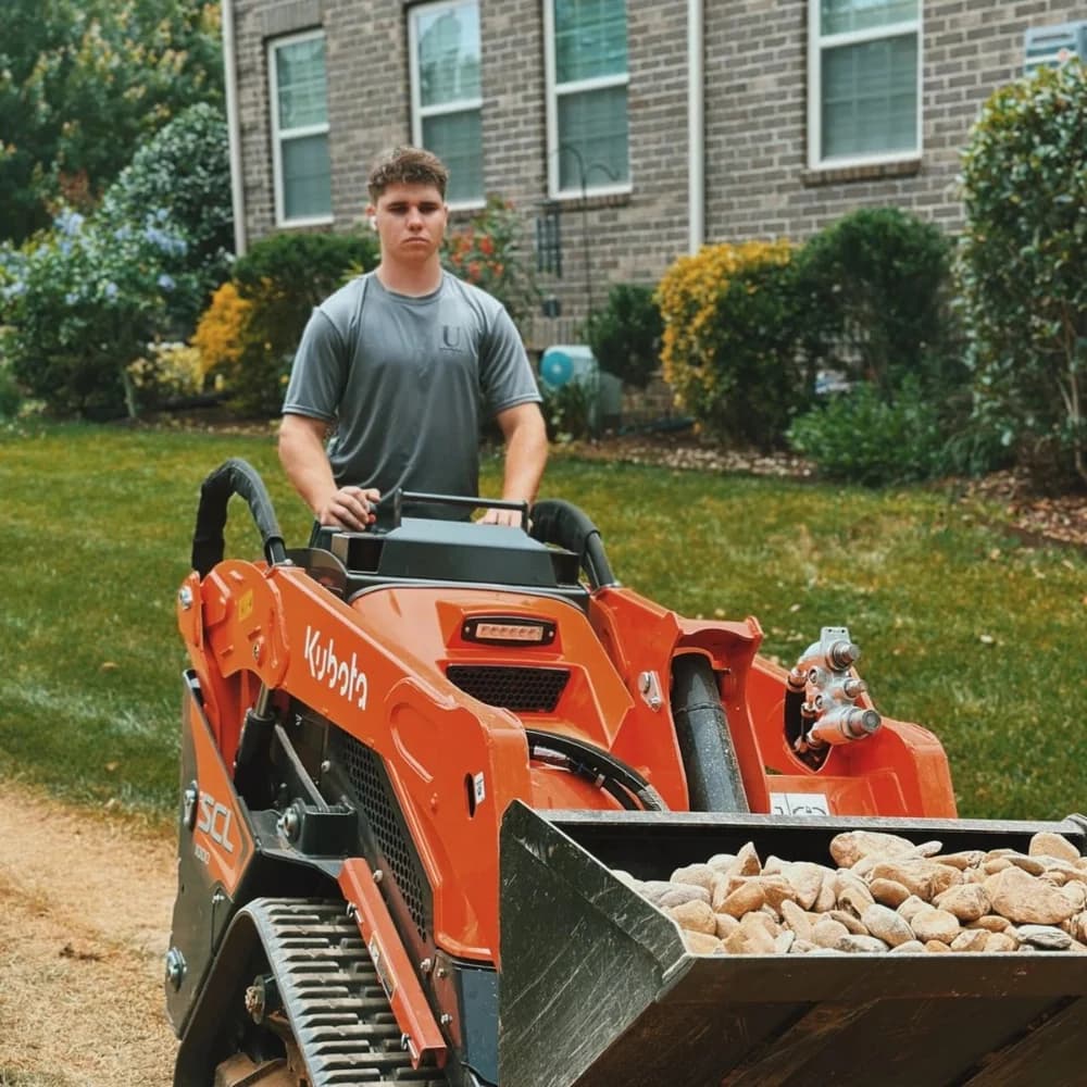 David Kravchenko operating a compact loader on a residential project